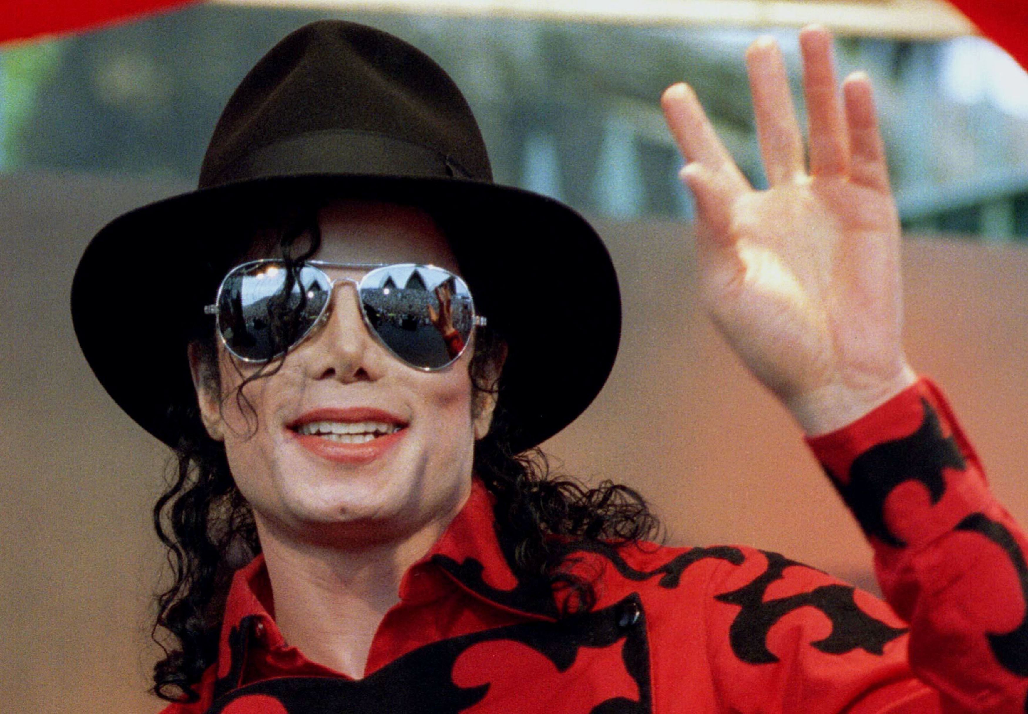 Michael Jackson waves to the crowd, numbering a few thousand, gathered in front of the Sydney Opera House in this November 17, 1996 file photo. Opening statements in civil trial over the death of Jackson begin April 29, 2013, with Katherine Jackson accusing concert promoters AEG Live of negligence in the hiring of convicted physician Dr. Conrad Murray. REUTERS/Megan Lewis/Files (AUSTRALIA - Tags: ENTERTAINMENT PROFILE OBITUARY)